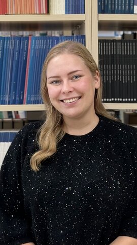 Naisterahvas raamatukogus raamaturiiulite ees.